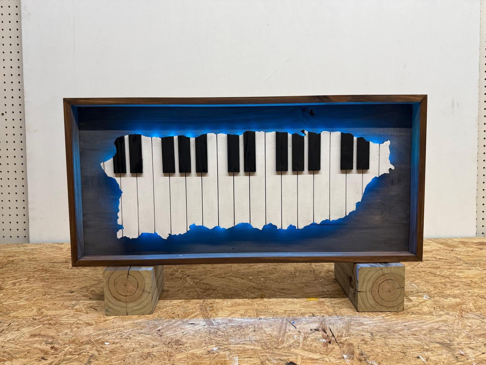 LED-backlit wooden wall art shaped like Puerto Rico with hand-carved piano keys